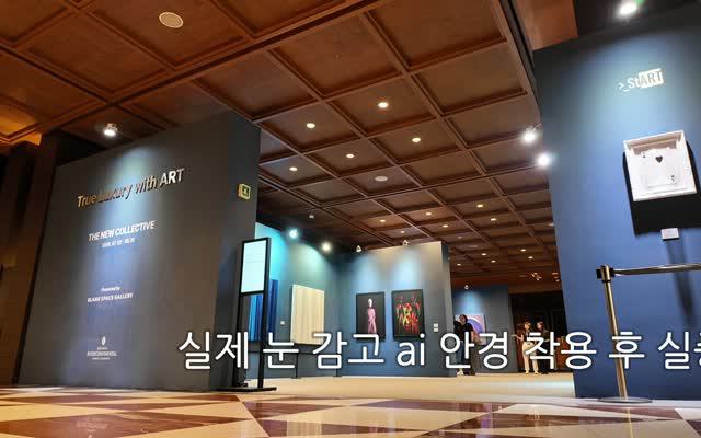 어두운 전시장 입구를 걸어 들어가는 1인칭 장면.
